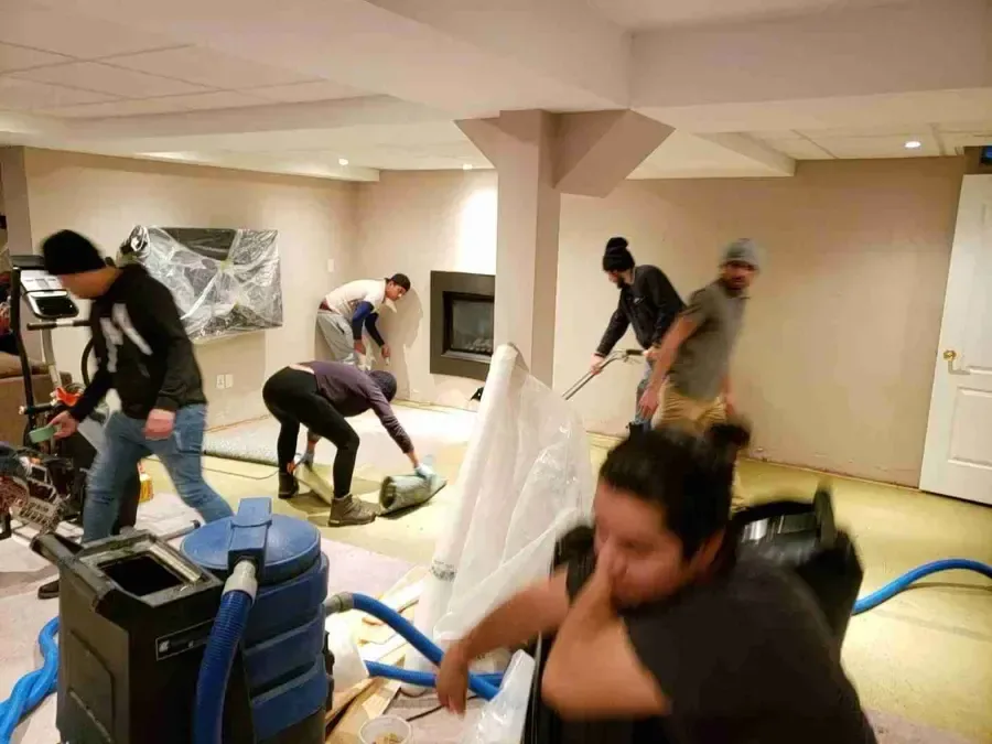 Air movers and a dehumidifier running inside a water damaged house