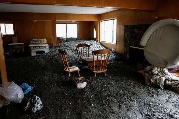Mud and debris left across a room after flood water drained away