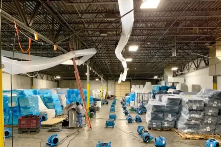 Rows of air movers drying a large warehouse floor